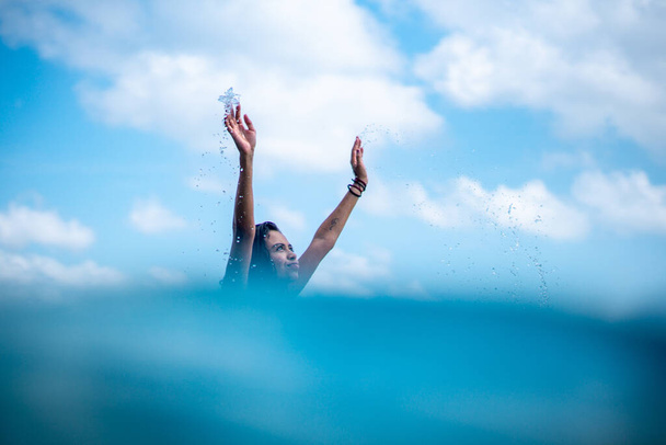 Retrato de surfista niña en tabla de surf blanca en el océano azul en la foto desde el agua en Bali - Foto, imagen