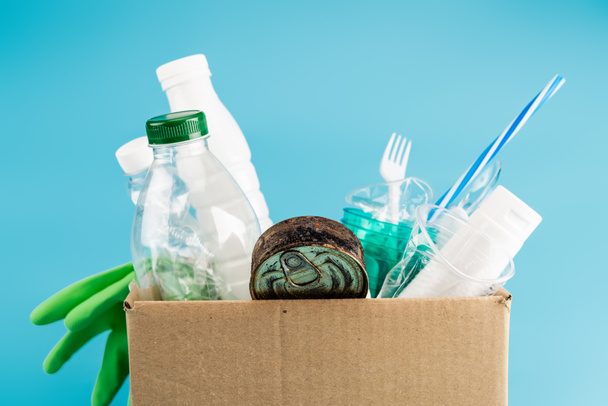 plastic rubbish and rubber gloves in cardboard box isolated on blue - Zdjęcie, obraz