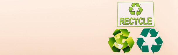 vista superior de los símbolos de reciclaje verde con el planeta y reciclar palabra aislada en beige, plano panorámico - Foto, imagen