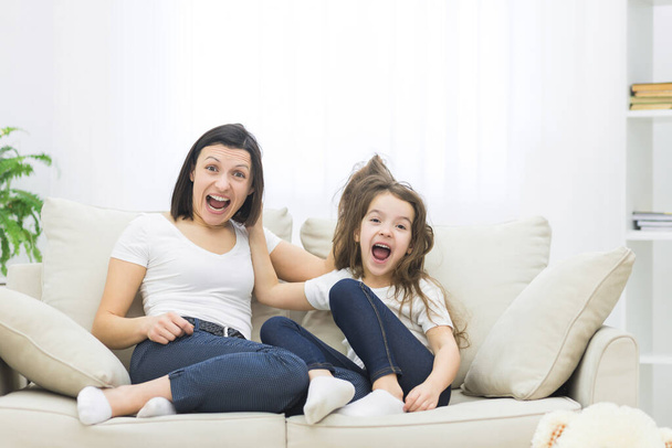 Close up photo of mother and daughter after quarrel on sofa at home. - 写真・画像