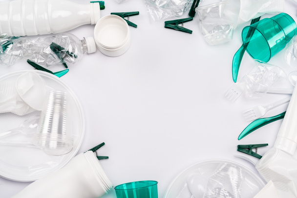 top view of plastic rubbish scattered on white background with copy space - 写真・画像