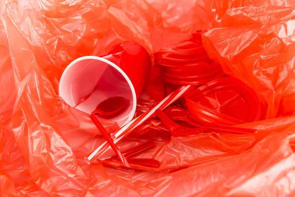 červené jednorázové předměty na plastové zmačkané textuře - Fotografie, Obrázek