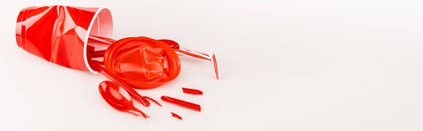 broken red plastic objects on white background, panoramic shot - 写真・画像