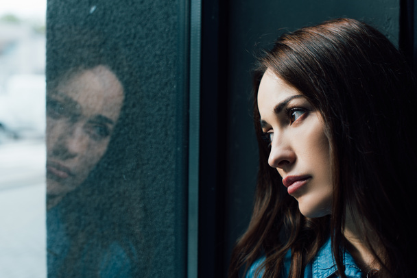 masentunut ja brunette nainen katselee ikkunaa  - Valokuva, kuva