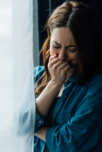 Frustrierte Frau weint und berührt Gesicht zu Hause  - Foto, Bild