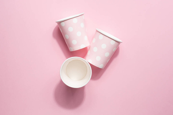 Polka dot disposable paper cups on pink background top view - Foto, imagen