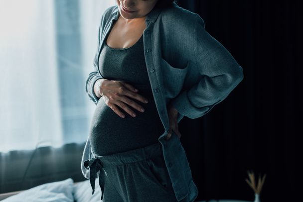 cropped view of pregnant woman suffering from pain and touching belly  - Φωτογραφία, εικόνα