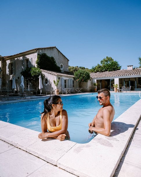 ζευγάρι χαλαρώνοντας δίπλα στην πισίνα στην Προβηγκία Γαλλία, άνδρες και γυναίκες χαλαρώνοντας με πισίνα στο πολυτελές θέρετρο - Φωτογραφία, εικόνα