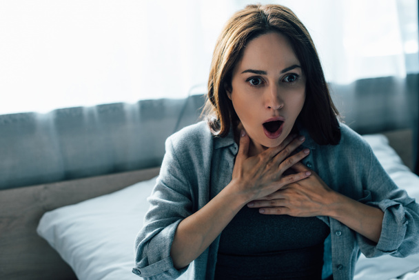 donna bruna spaventata che tocca la gola mentre ha un attacco di panico  - Foto, immagini