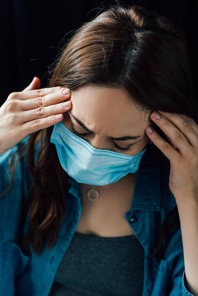 donna bruna in maschera medica toccare la testa a casa  - Foto, immagini