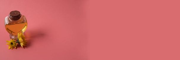 Ätherisches Öl mit Kamillenblütenextrakt. Auf rosa Hintergrund, Kopierraum. - Foto, Bild