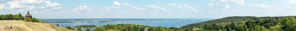 Paysage panoramique de belle vue sur la rivière Dniepr avec chapelle en bois, forêt et ciel bleu avec nuages à Vitachov, Ukraine. Parc national Horodyshche Novgorod-Svyatopolche. Repère historique - Photo, image