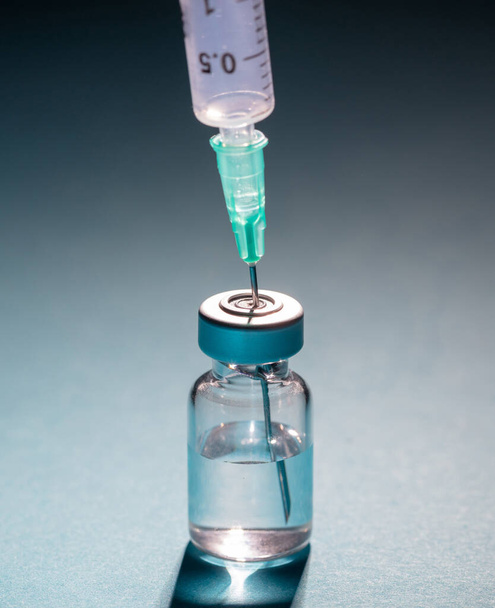 Vaccine, coronavirus vaccination, covid-19 flu prevention, immunization concept. Vial dose and medical syringe, drug medicine shot injection, gray blue background, closeup. - Photo, Image
