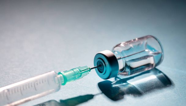 Vaccine, coronavirus vaccination, covid-19 flu prevention, immunization concept. Vial dose and medical syringe, drug medicine shot injection, gray blue background, closeup. - Photo, Image