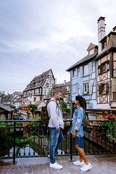 couple on city trip Colmar, Alsace, France. Petite Venice, water canal and traditional half timbered houses. Colmar is a charming town in Alsace, France. Beautiful view of colorful romantic city - 写真・画像