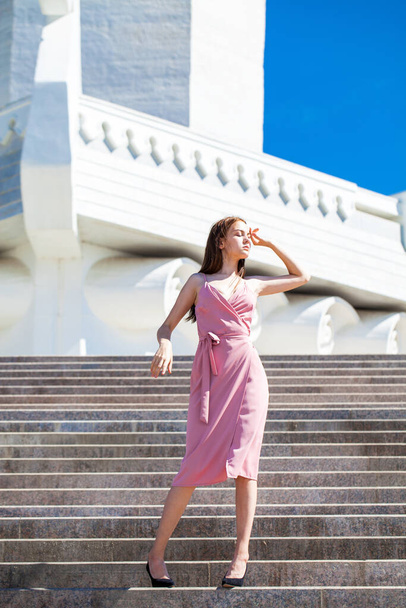 полный портрет молодой красивой женщины в летнем платье, позирующей на фоне ладьи-памятника в Самаре - Фото, изображение