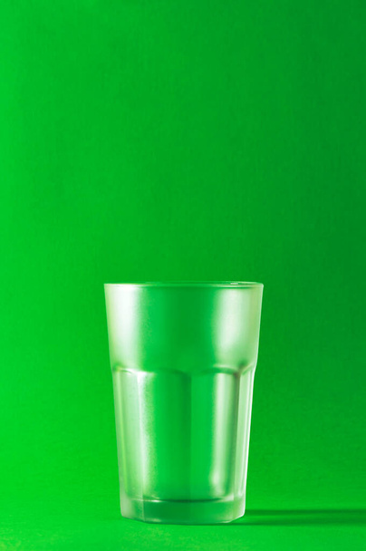 Vidrio vacío sobre fondo verde, enfoque selectivo. - Foto, Imagen