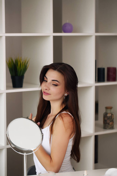 Beauty, skincare and people concept - smiling young girl suggesting beauty for on face in room - Фото, изображение
