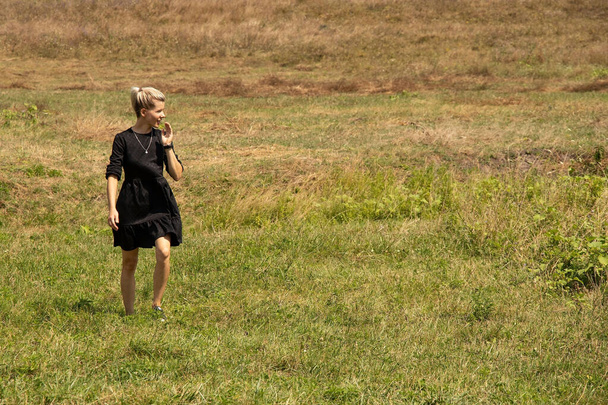 Ένα κορίτσι περπατά σε ένα χωράφι στην Ουκρανία τον Αύγουστο στην πόλη Ντνίπρο μια ηλιόλουστη μέρα - Φωτογραφία, εικόνα