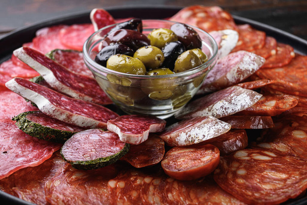 Antipasto platter cold meat with chorizo, fuet,salami, salchichon and longaniza on dark wooden background. - Foto, immagini