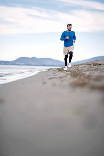Man jogging on the beach in the morning - Fotoğraf, Görsel