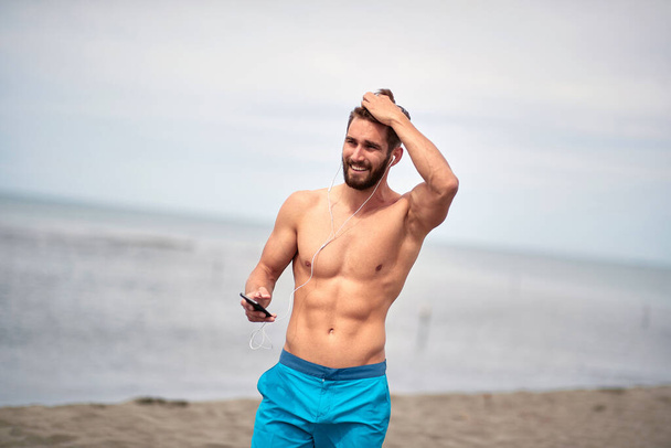 Attractive handosme man posing on the beach; Hot guy concept - Valokuva, kuva