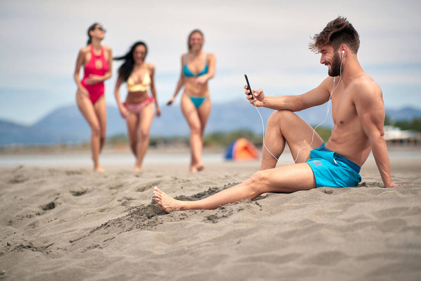 Guy waiting for his friends on the beach - Φωτογραφία, εικόνα