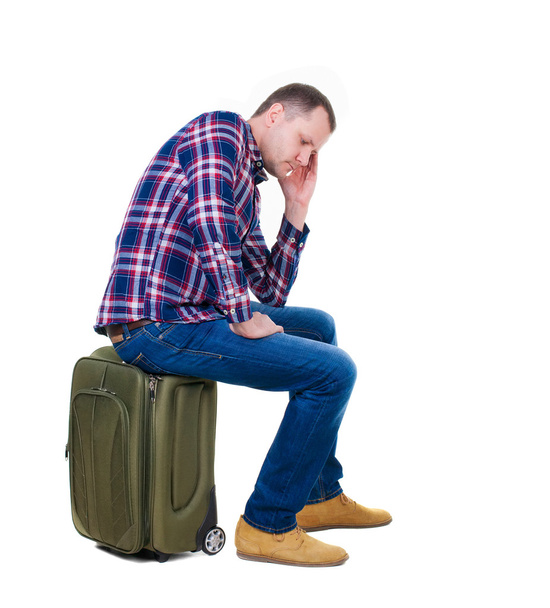 Man sitting on a suitcase - Foto, afbeelding