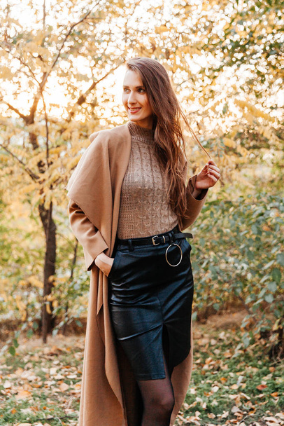 beautiful girl in a coat, black skirt and jacket autumn walks in a hat - Φωτογραφία, εικόνα