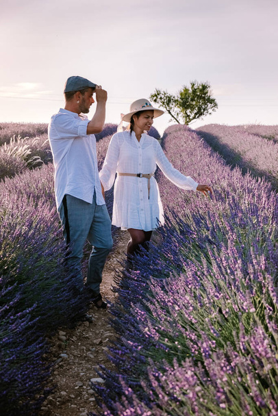 Couple men and woman on vacation at the provence lavender fields, Provence, Lavender field France, Valensole Plateau, colorful field of Lavender Valensole Plateau, Provence, Southern France. Lavender - Photo, Image
