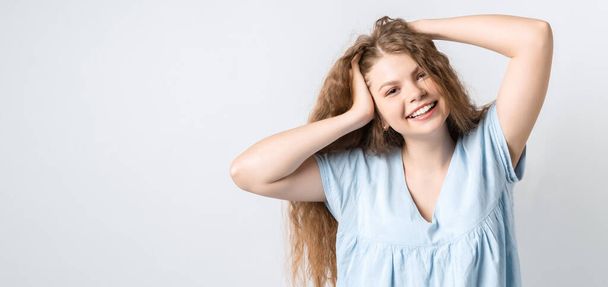 Portrait of attractive carefree european girl, tilting head up and shaking curly hair. Living life to fullest. Having fun and being amused. Copy space for your text - Photo, Image