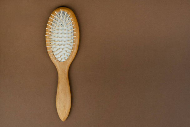 Massage comb with wooden handle on table. Device for combing hair. Eco beauty concept. - Фото, зображення