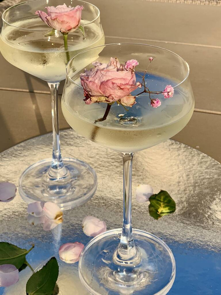 wineglasses with champagne and flowers in the party - Photo, Image