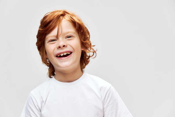 Vidám vörös hajú fiú fehér póló mosoly stúdió öröm  - Fotó, kép
