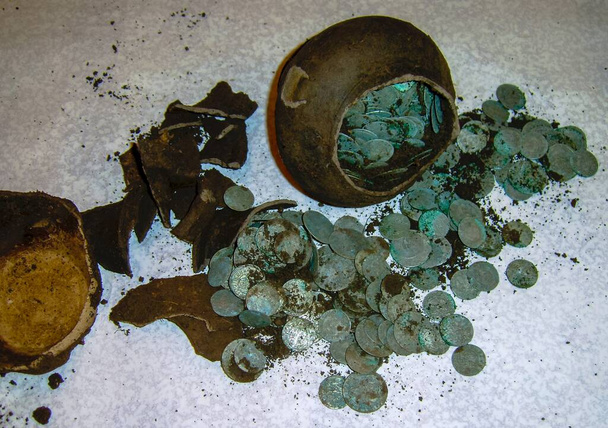 сокровище серебряных монет времен пиратов и нож на красной бархатной ткани крупным планом - Фото, изображение