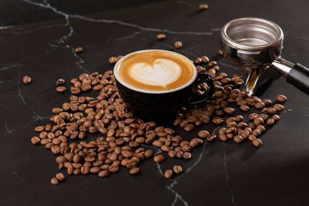 Cup of hot latte coffee with beautiful milk foam latte art texture with coffee bean on black marble background. Overhead view, copy space. Advertising for cafe menu. Coffee shop menu. - Photo, image