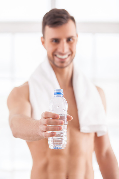 Muscular man holding a bottle - Фото, зображення