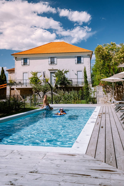Francia nyaraló fapadlóval és medencével az Ardeche Franciaországban. Pihenő pár a medence mellett fapadlóval a luxus nyaralás alatt egy nyaralóban Dél-Franciaországban - Fotó, kép