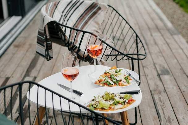 Pizza maison et apéro boisson sur la terrasse moderne en bois, dîner pour deux. Délicieuses pizzas et cocktails pour la fête à la maison. Vacances d'été et resort. - Photo, image