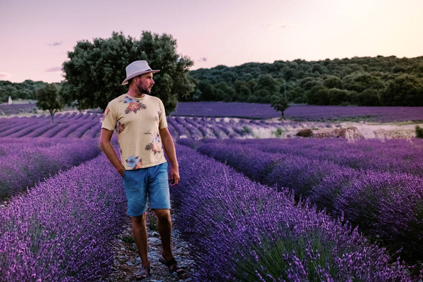 Lavendelvelden in de Ardeche in het zuiden van Frankrijk tijdens zonsondergang, Lavendelvelden in de Ardeche in het zuidoosten van Frankrijk, mannen en vrouwen die de zonsondergang in lavendelvelden in het zuiden van Frankrijk gadeslaan - Foto, afbeelding