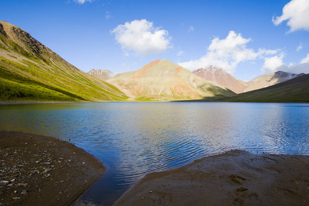 Alpejskie jezioro w ciągu dnia, światło słoneczne i kolorowy krajobraz w Khazbegi, Gruzja. Jezioro Khelitsadi. - Zdjęcie, obraz
