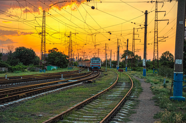 viejo tren eléctrico de múltiples unidades en los ferrocarriles a la entrada de la estación al amanecer en Mariupol, Ucrania - Foto, Imagen