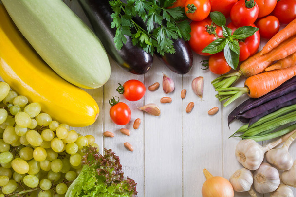 Свежие овощи и фрукты на белой деревянной столешнице - Фото, изображение