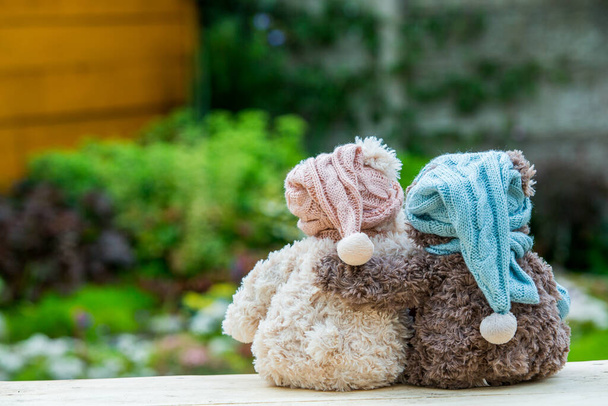 Two teddy bears sitting on the bench and hugging each other, rear view. Greeting or gift card design idea. - Photo, Image