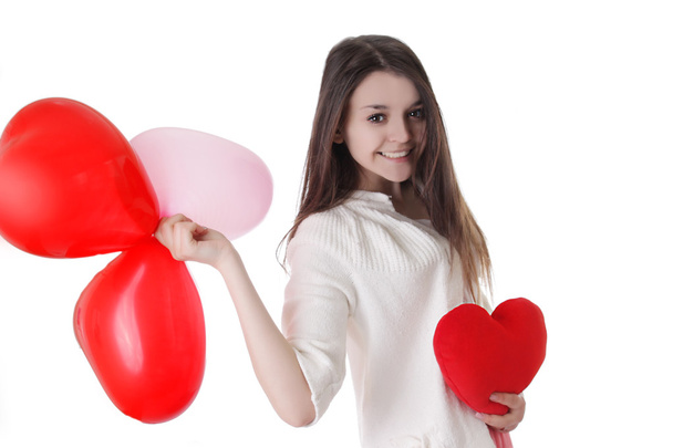 lachende jong meisje met ballonnen en pluche hart - Foto, afbeelding