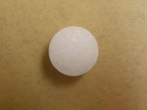 Small white color Naphthalene mothball on wood background - Photo, Image