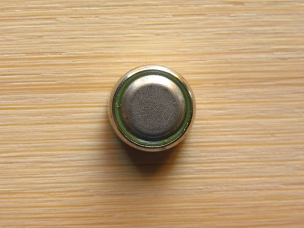 Маленька срібна комірка кнопок на фоні дерева
 - Фото, зображення