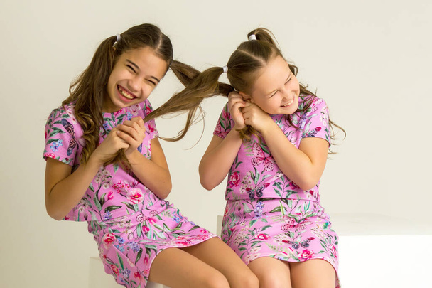 Little girls pull each others pigtails. - Foto, afbeelding