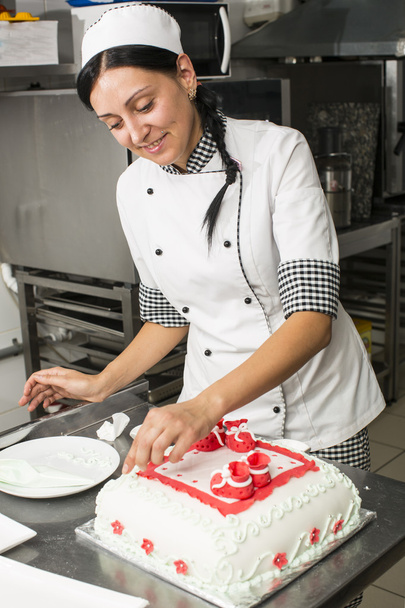 Pastry chef decorates a cake - Фото, изображение