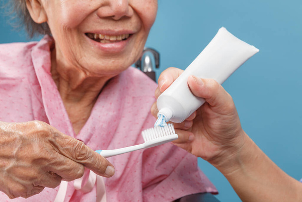 Cuidador cuidar asiático anciano mujer mientras usa cepillo de dientes. - Foto, imagen
